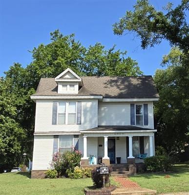 view of front of home with a porch and a front lawn