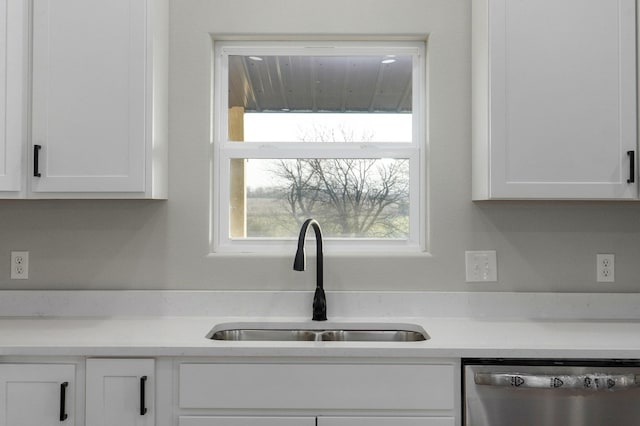 details with dishwasher, white cabinetry, and sink