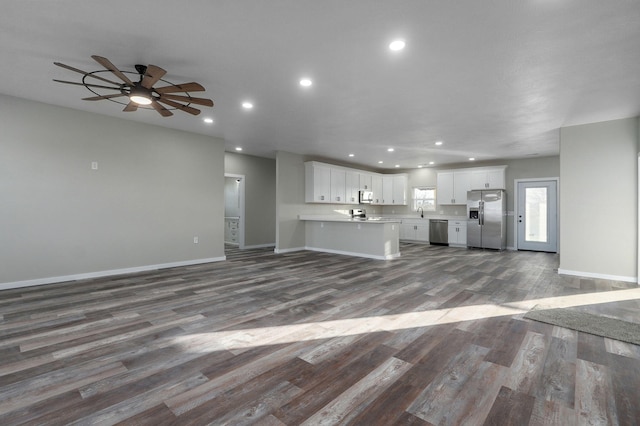 unfurnished living room with ceiling fan and dark hardwood / wood-style flooring