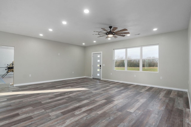 unfurnished living room featuring ceiling fan and dark hardwood / wood-style flooring