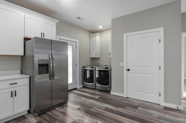 kitchen with white cabinetry, stainless steel fridge, dark wood-type flooring, and washer and dryer