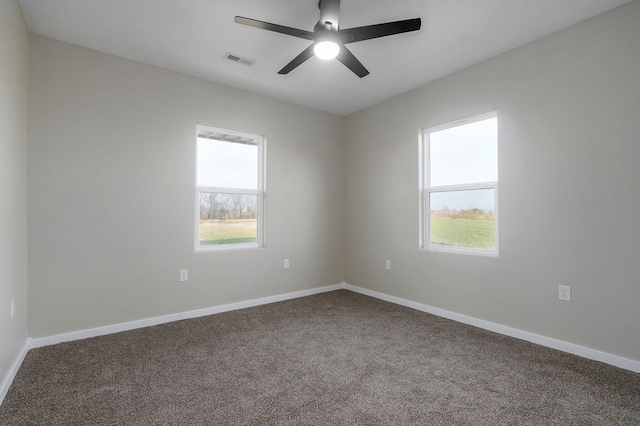 carpeted empty room featuring a wealth of natural light and ceiling fan