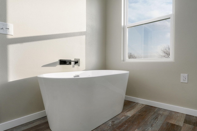 bathroom with a bath and wood-type flooring