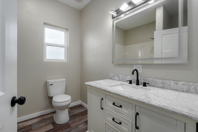 bathroom featuring hardwood / wood-style floors, vanity, toilet, and a shower