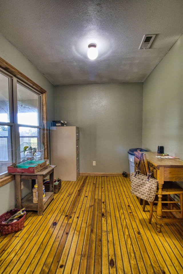 interior space with a textured ceiling and hardwood / wood-style flooring