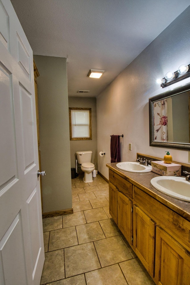 bathroom with tile patterned floors, vanity, and toilet