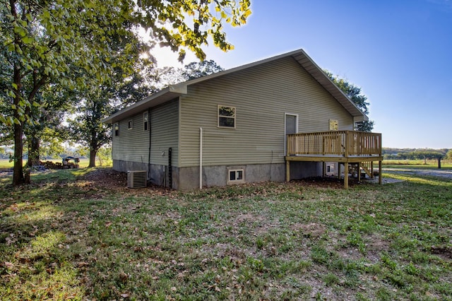 rear view of house featuring a yard, cooling unit, and a deck