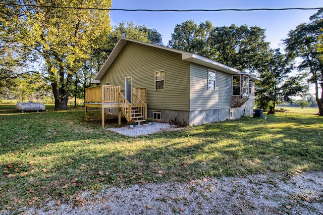 back of house featuring a lawn, a deck, and central AC