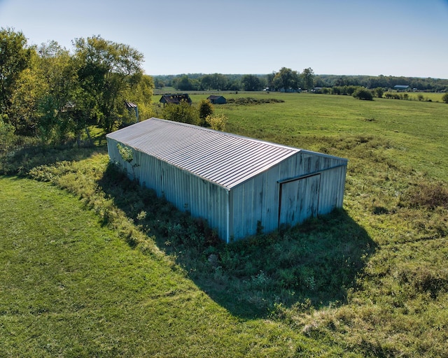 view of outbuilding featuring a lawn and a rural view