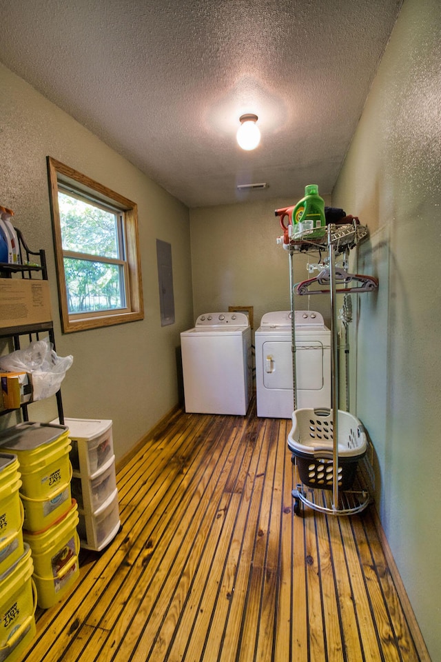 clothes washing area featuring independent washer and dryer, dark hardwood / wood-style flooring, electric panel, and a textured ceiling