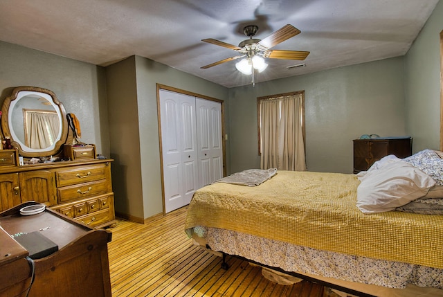 bedroom featuring ceiling fan, light hardwood / wood-style flooring, and a closet