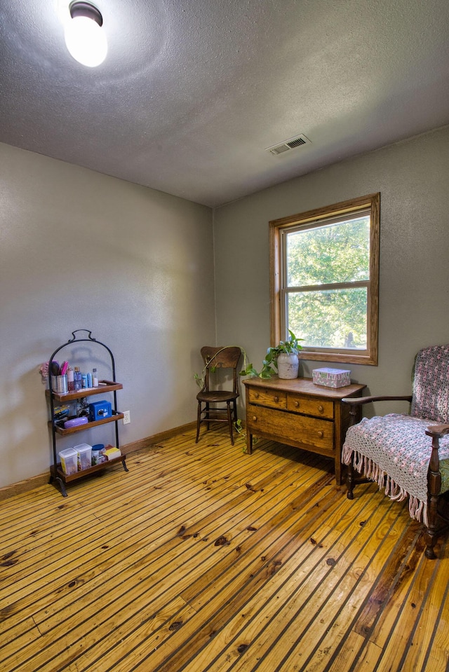 sitting room featuring hardwood / wood-style flooring and a textured ceiling