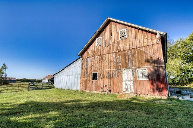 rear view of house featuring a lawn and an outbuilding