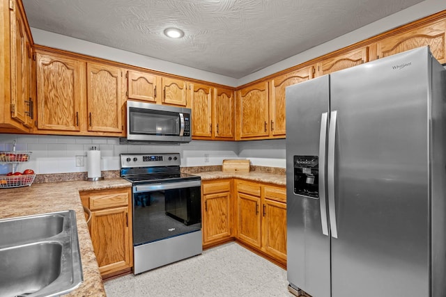 kitchen with decorative backsplash, stainless steel appliances, and sink