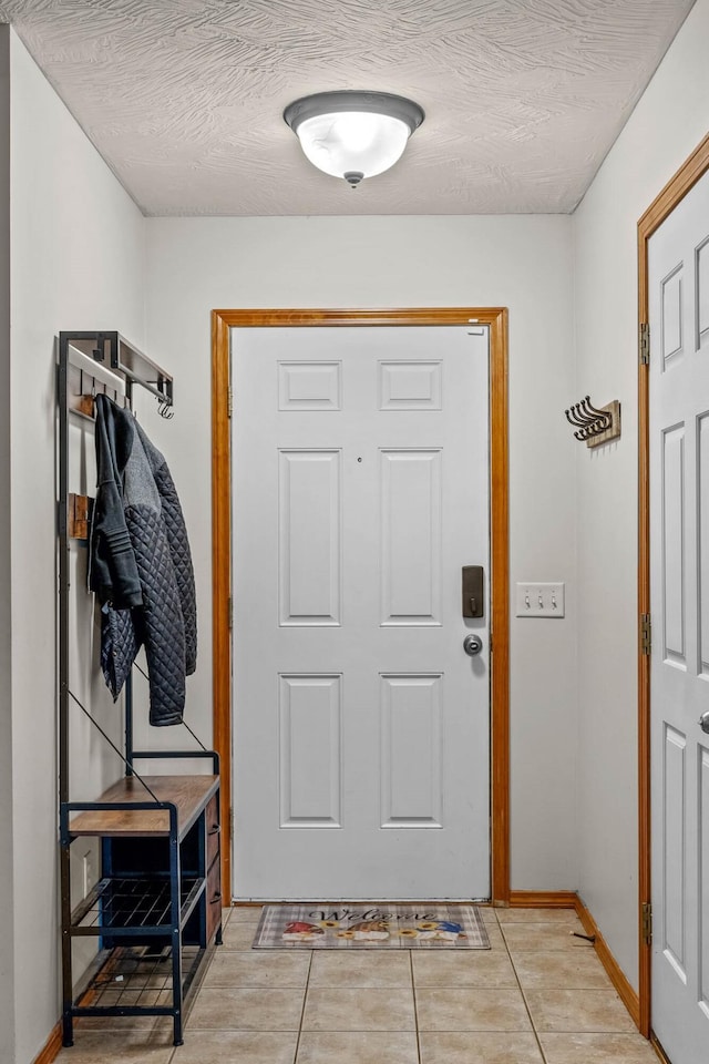 interior space featuring light tile patterned floors and a textured ceiling