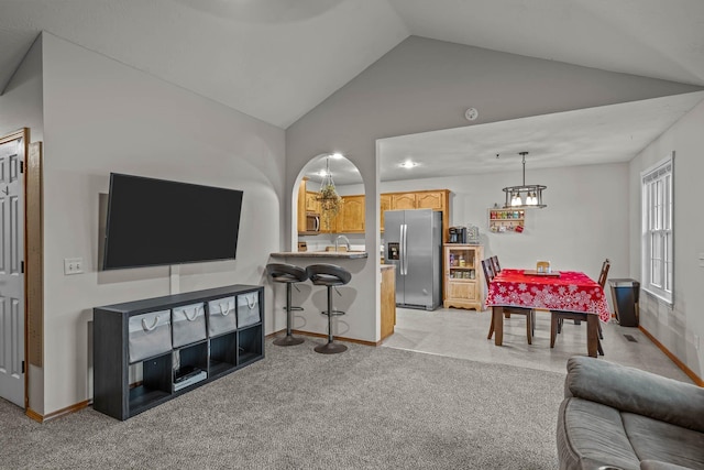 carpeted living room with vaulted ceiling and sink