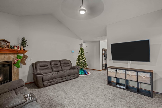 living room featuring carpet flooring, a tiled fireplace, ceiling fan, and lofted ceiling