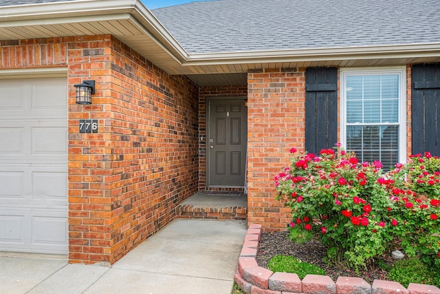 776 S Pinehurst St, Nixa, MO 65714 - view of exterior entry with a shingled roof, brick siding, and an attached garage