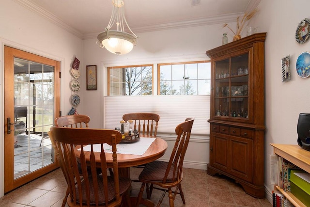 dining room with light tile patterned floors, crown molding, and plenty of natural light