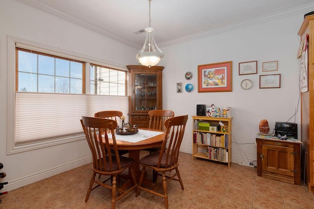 dining area with ornamental molding and light tile patterned flooring