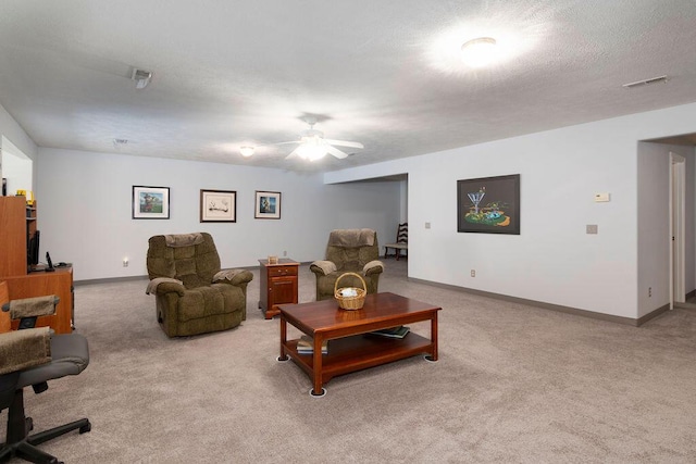 carpeted living room with ceiling fan and a textured ceiling