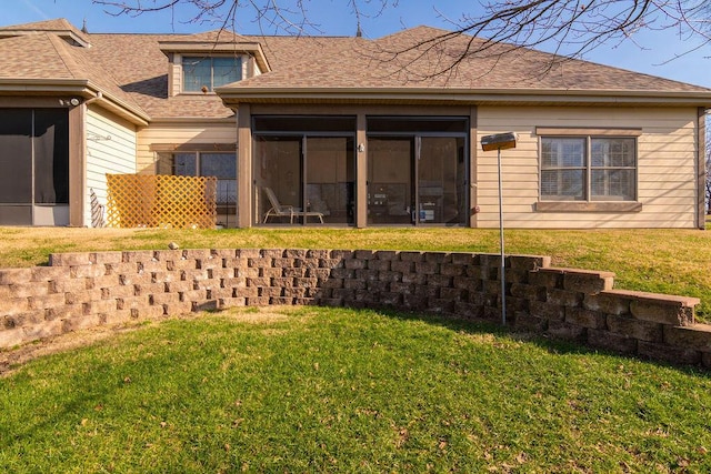 rear view of house featuring a sunroom and a yard