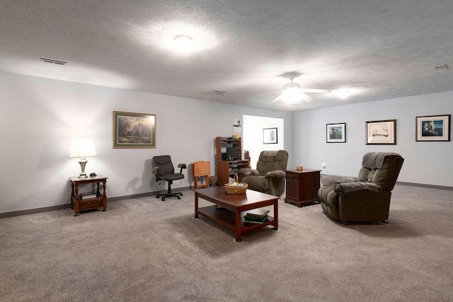 carpeted living room with ceiling fan and a textured ceiling