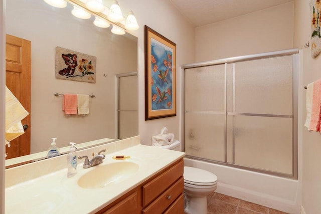 full bathroom with vanity, tile patterned flooring, shower / bath combination with glass door, and toilet