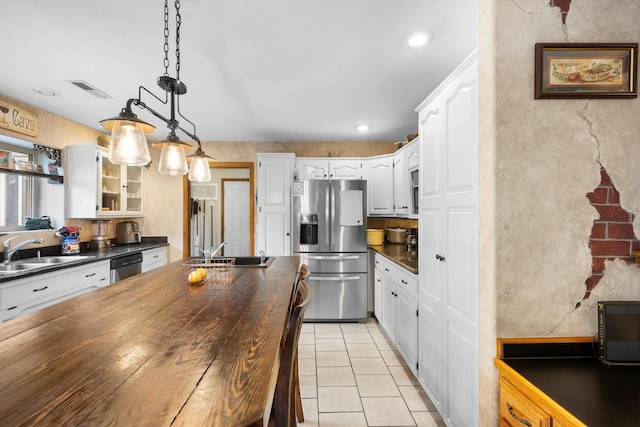 kitchen featuring appliances with stainless steel finishes, decorative light fixtures, white cabinetry, and sink