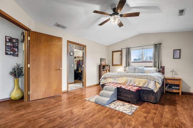 bedroom with ceiling fan, a spacious closet, hardwood / wood-style floors, lofted ceiling, and a closet