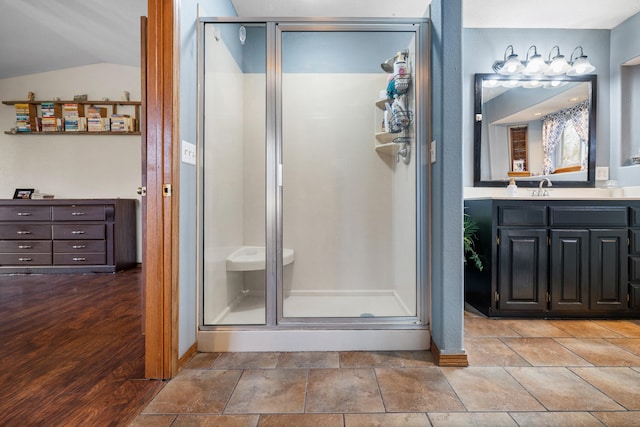 bathroom featuring a shower with door, vanity, and lofted ceiling