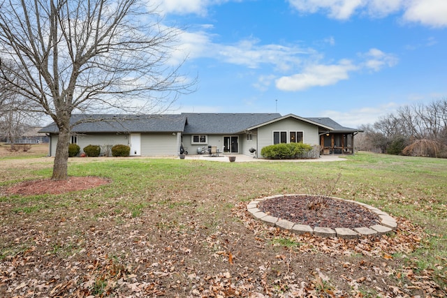 back of property with a yard, a patio, and a sunroom