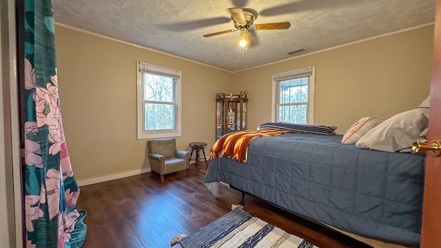 bedroom featuring a textured ceiling, ceiling fan, crown molding, dark wood-type flooring, and multiple windows