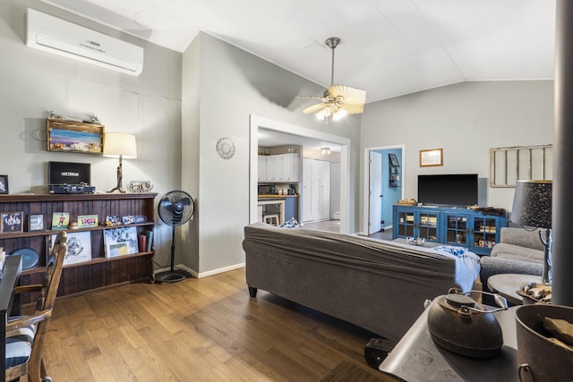 living room featuring hardwood / wood-style flooring, an AC wall unit, ceiling fan, and lofted ceiling