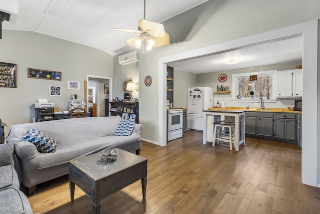 living room with a wall unit AC, ceiling fan, dark wood-type flooring, sink, and lofted ceiling