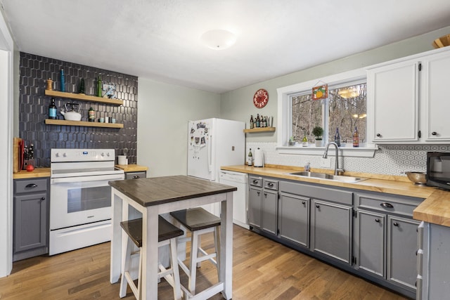 kitchen featuring backsplash, gray cabinets, sink, and white appliances