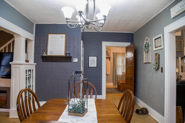 dining area featuring hardwood / wood-style floors, crown molding, and an inviting chandelier