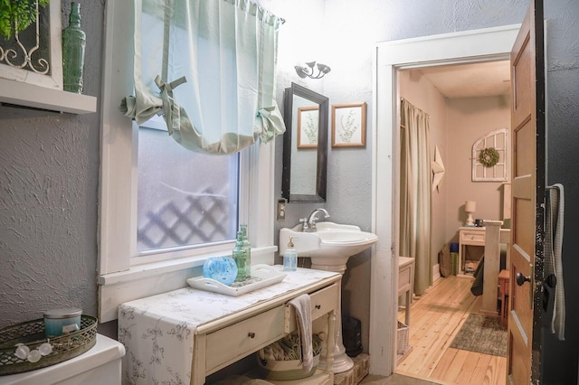 bathroom with sink, toilet, and hardwood / wood-style flooring