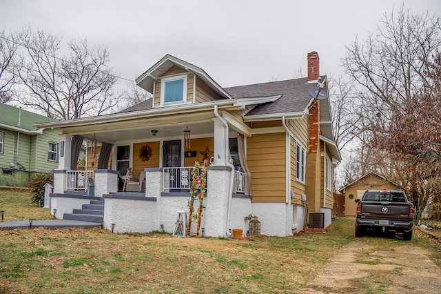 bungalow with a porch and central air condition unit