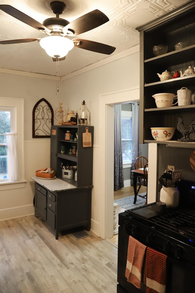 interior space featuring ceiling fan, plenty of natural light, crown molding, and light hardwood / wood-style flooring