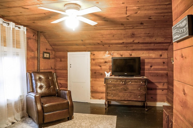 sitting room featuring lofted ceiling and wooden walls