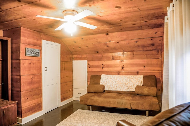 living area with ceiling fan, dark hardwood / wood-style floors, wood walls, vaulted ceiling, and wood ceiling