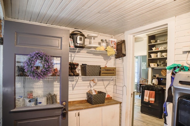 interior space featuring washer / dryer, light hardwood / wood-style flooring, and wooden ceiling