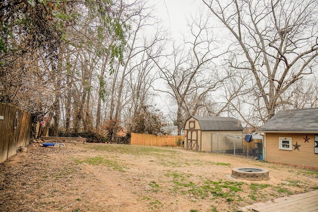 view of yard with a shed and an outdoor fire pit