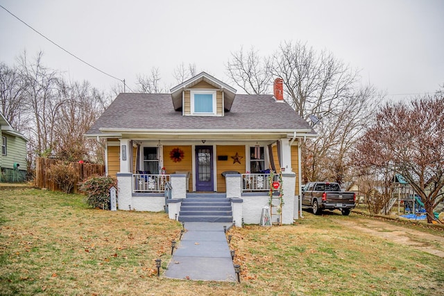 bungalow with covered porch and a front yard