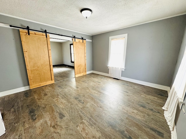 empty room featuring a barn door and a textured ceiling