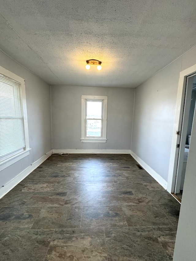 unfurnished room with a textured ceiling