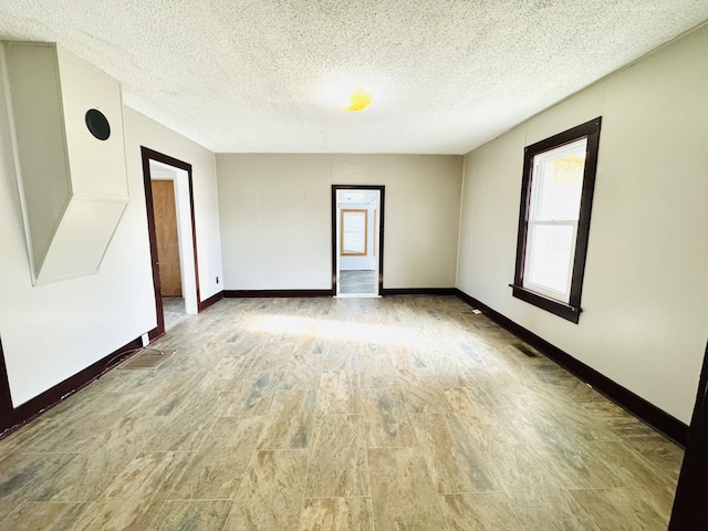 unfurnished room with a textured ceiling