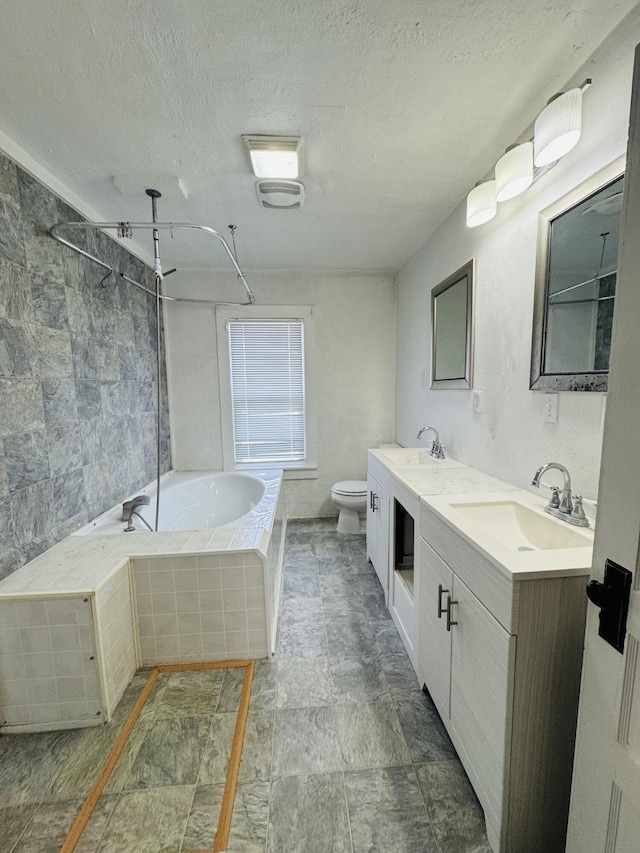 full bathroom with vanity, shower with separate bathtub, toilet, and a textured ceiling