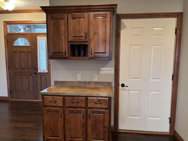 kitchen featuring dark brown cabinetry and dark wood-type flooring